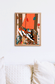 Affiche Air d'automne tenue dans son cadre noir, fond rose fuchsia et canapé orange
