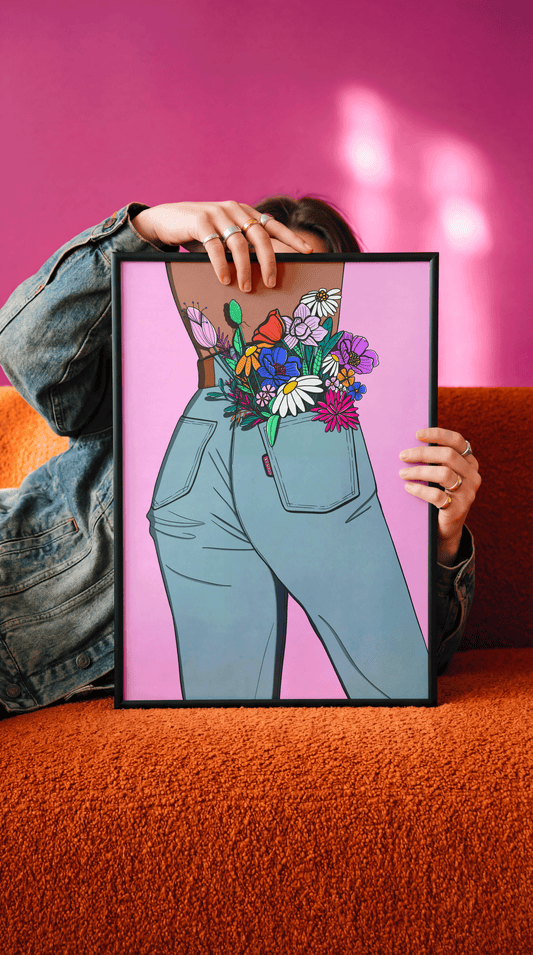 Affiche Flower in my pocket tenue dans son cadre noir, fond rose fuchsia et canapé orange